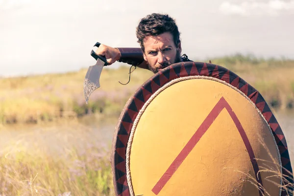 Portrait of fighting ancient warrior in armor with sword and shield — Stock Photo, Image