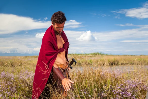 Bestrijding van oude krijger in landschap achtergrond — Stockfoto