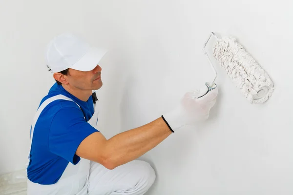 Painter painting a wall with paint roller — Stock Photo, Image