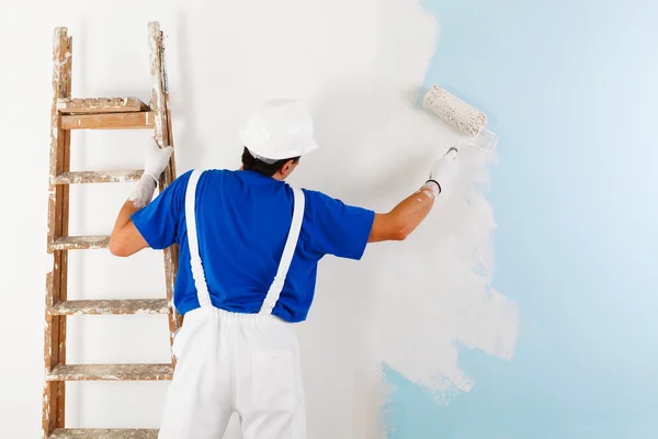 Schilder schilderij een muur met verfroller — Stockfoto