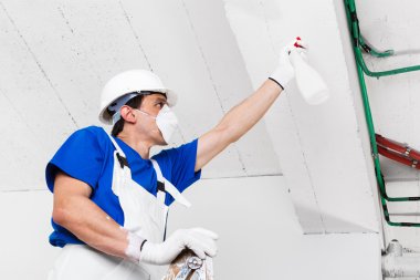 worker spraying ceiling with spray bottle  clipart