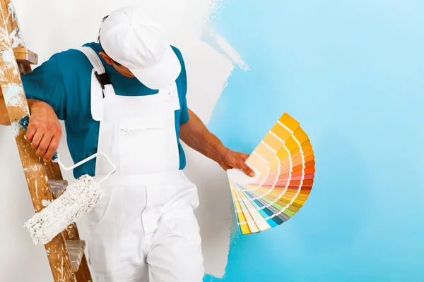 Painter  with paintroller showing a color palette — Stock Photo, Image