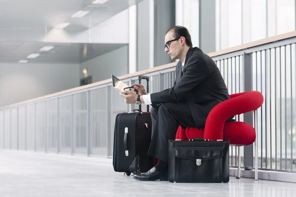 Business man using his Tablet at exhibition lobby