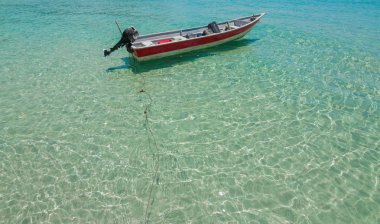 temiz su ve mavi gökyüzü ile sahilde tekne