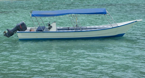 Boot aan het strand met helder water en blauwe luchten — Stockfoto