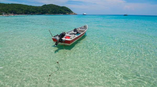 Barco junto a la playa con agua clara y cielos azules —  Fotos de Stock