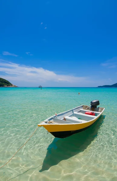 Barco junto a la playa con agua clara y cielos azules —  Fotos de Stock
