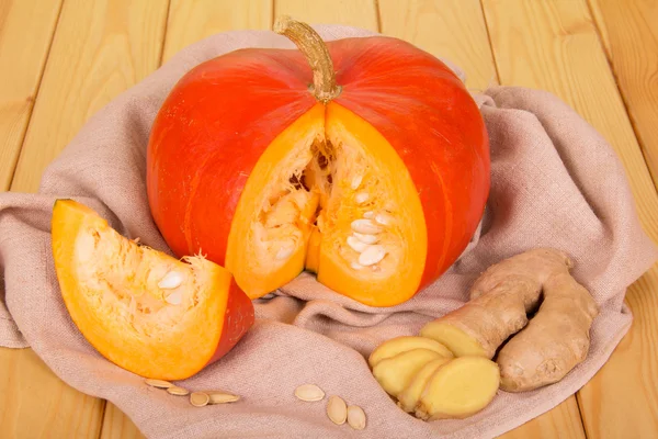 Calabaza naranja cortada con jengibre sobre fondo de madera —  Fotos de Stock