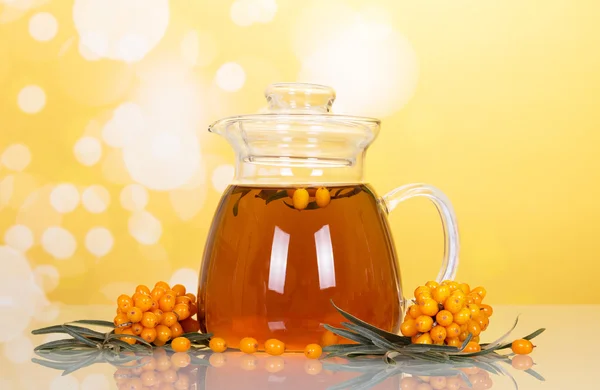 Sea buckthorn branches with tea and berries on yellow — Stock Photo, Image