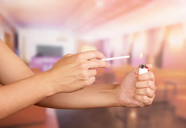 Mano femenina con encendedor y cigarrillo en la cafetería — Foto de Stock