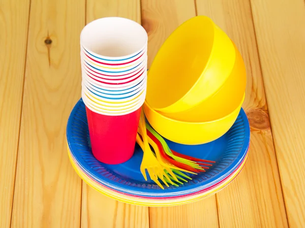 Kleurrijke wegwerp servies op een houten tafel — Stockfoto
