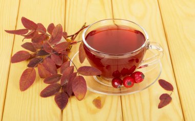 Hafif kahverengi ahşap arka plan kalçalarına üzerinden içkiyle Kupası