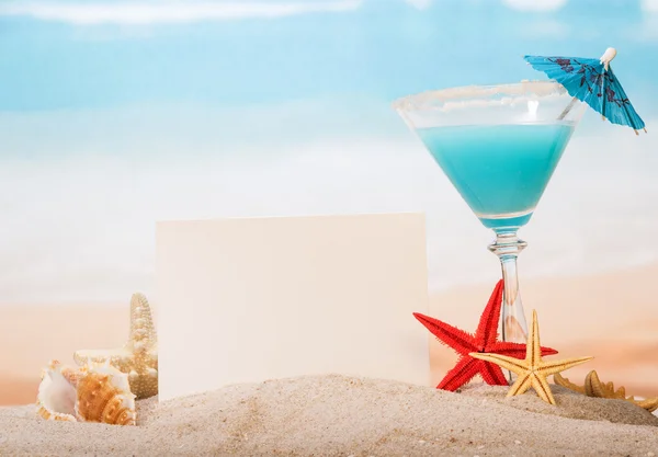 Carta bianca, cocktail e stella nella sabbia in riva al mare — Foto Stock