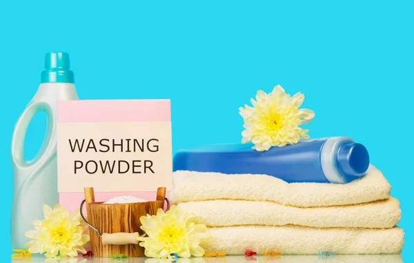 Clean towels with means for washing and yellow flowers — Stock Photo, Image