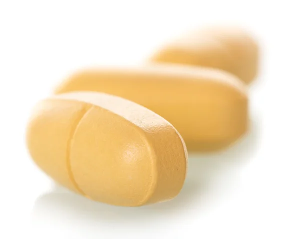 Macro large yellow pills isolated on white — Stock Photo, Image