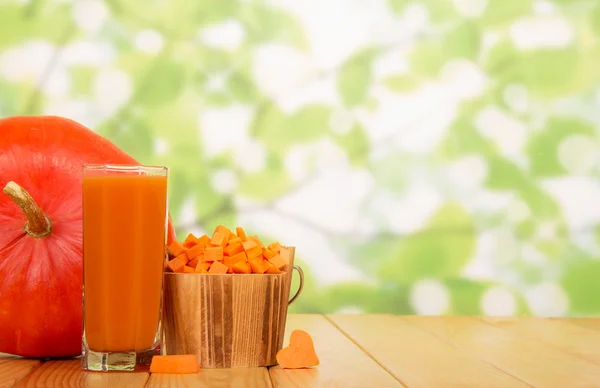 Bitar av pumpa i en trä hink och juice — Stockfoto