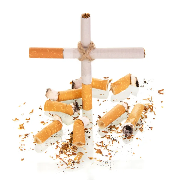 La composizione sotto forma di croce e sigaretta affumicata isolata su bianco — Foto Stock