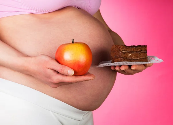 Pregnant woman with Apple and cake in isolation — Stock Photo, Image