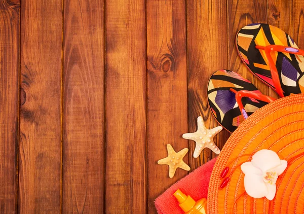 Beach slippers, hat and towel on  background of dark wood — Stock Photo, Image