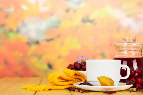 Krug und Tasse mit Wellnessgetränk aus der Wildrose auf dem Untergrund o Herbstblätter — Stockfoto