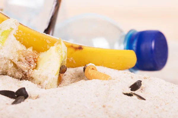 Cigarettfimpar, hushåll och mat avfall i sanden på stranden. — Stockfoto