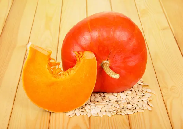 Calabaza fresca y semillas de girasol en contra de la madera pálida . —  Fotos de Stock