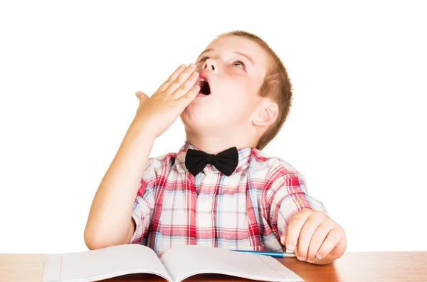 Yawning boy sitting at notebook isolated on white . — Zdjęcie stockowe