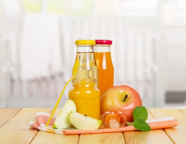 Bouteilles de jus de différents types de pommes sur la cuisine de fond . — Photo