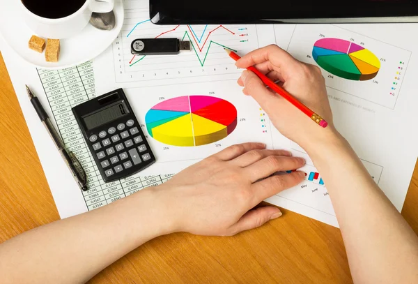 Lápiz en mano femenina en el fondo del escritorio . — Foto de Stock