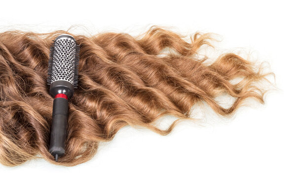 Comb and strands of curly hair isolated on white.