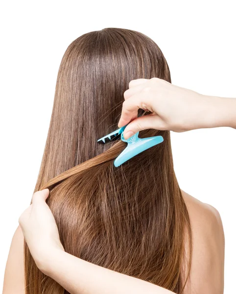 A menina com o cabelo marrom longo faz o cabelo. Isolado em branco  . — Fotografia de Stock