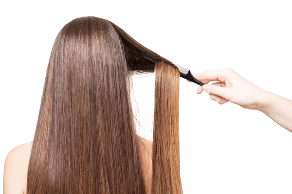 Friseurkämme Hand luxuriöse lange Haare isoliert auf weiß. — Stockfoto