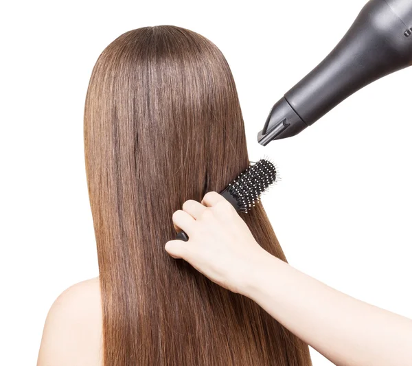 Trocknen lange braune Haare mit Haartrockner und Kamm isoliert. — Stockfoto