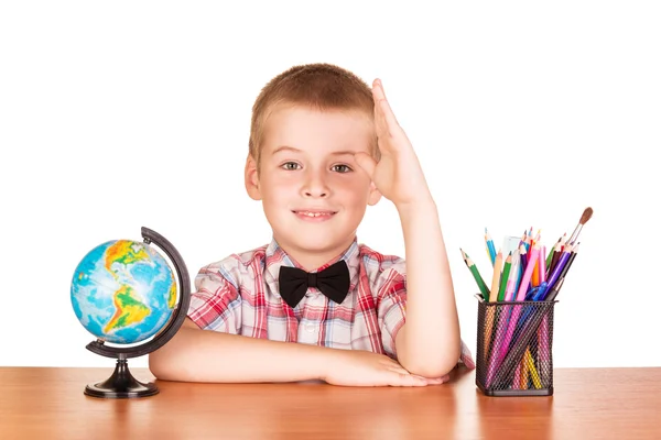 Cute uczniak na biurku, kuli ziemskiej i ołówki izolowane . — Zdjęcie stockowe