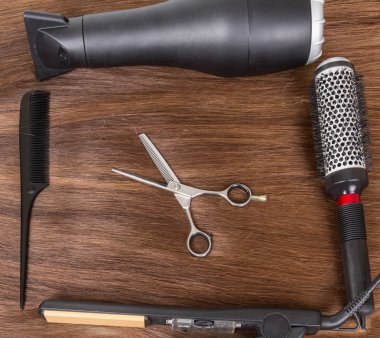Saç kurutma makinesi, saç maşası, tarak ve kahverengi saç için makaslar.
