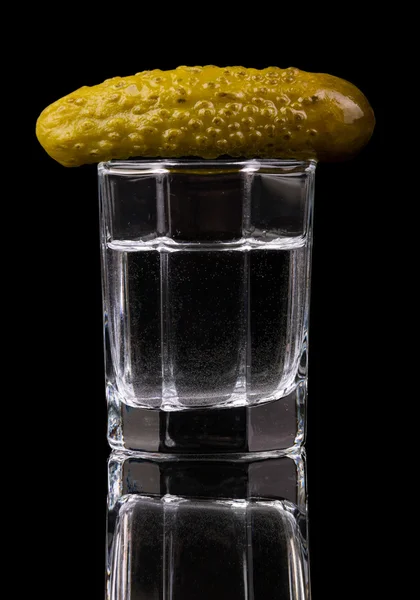 Glas vodka med saltgurka isolerad på svart bakgrund. — Stockfoto