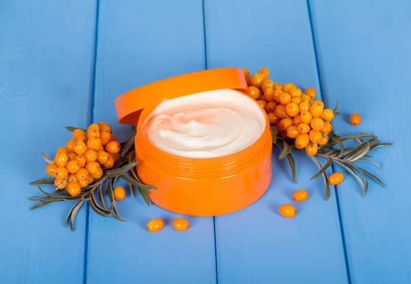 Seabuckthorn en bank met crème-gekleurde achtergrond op hout blauw. — Stockfoto