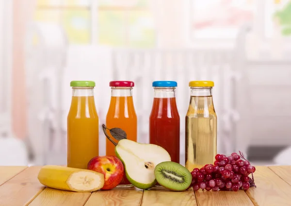 Butelki z świeżych owoców sok na tle kuchnia. Żywność dla niemowląt. — Zdjęcie stockowe