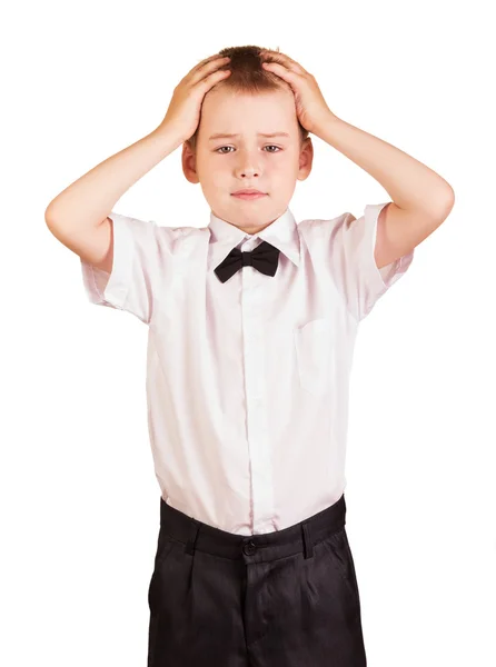 Puzzled schoolboy holds hands  head isolated on white background. Stock Photo