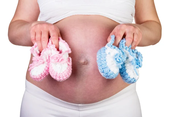 Embarazada mujer sosteniendo azul y rosa botines aislado en blanco . —  Fotos de Stock