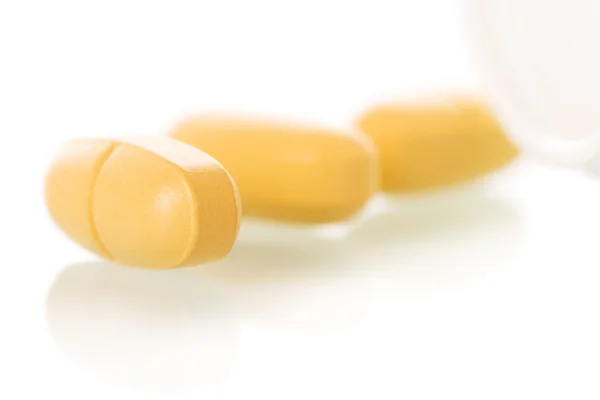 Yellow pills close-up isolated on white. — Stock Photo, Image