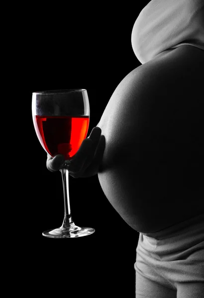 Těhotná žena drží sklenici červeného vína izolovaných na černém. — Stock fotografie