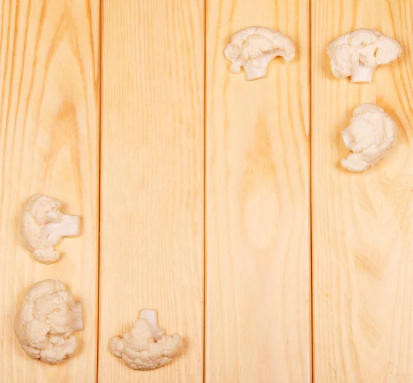 Trozos de coliflor cruda en primer plano sobre madera clara de fondo . —  Fotos de Stock