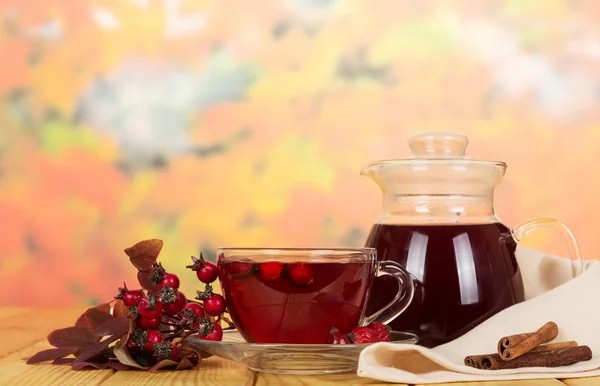 Kannan, te Nypon bär på bakgrund av höstlöv. — Stockfoto