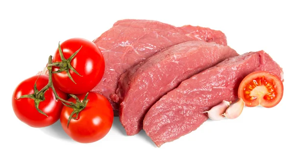 Pedaços de carne fresca, tomates e alho isolados sobre fundo branco . — Fotografia de Stock