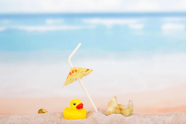 Бытовые отходы и резиновая утка в песке у моря . — стоковое фото