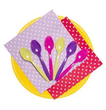 Tek kullanımlık tabak, renkli kaşık ve üzerinde beyaz izole peçeteler.