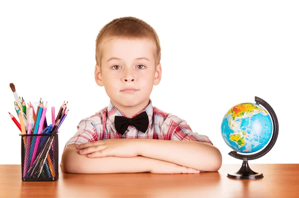 Söt Schoolboy, Globe och blyertspennor på bordet isolerade . — Stockfoto