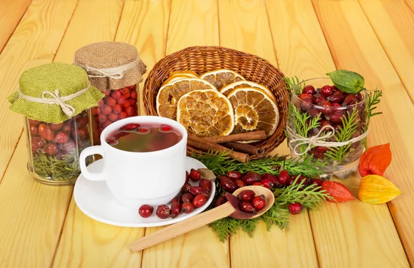 Bayas de otoño, té, rodajas limón, canela sobre fondo madera clara . — Foto de Stock