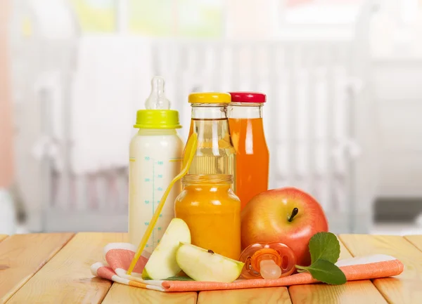 Bottiglie con latte, succhi di frutta, banca di purea di frutta sullo sfondo cucina . — Foto Stock